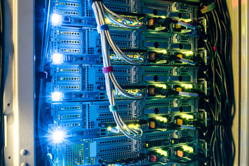 Computer technology works in a dark server room of the data center. Bright indication on network...