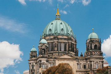 The Berlin Cathedral is called Berliner Dom against the blue sky. Beautiful old building in the style of neoclassicism and baroque with cross and sculptures. Berlin, Germany