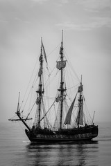Historical boat with three masts on the ocean.