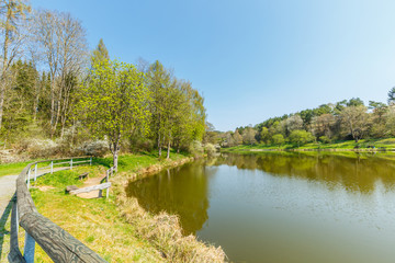 Fototapeta na wymiar Lake Stausee in the hills at the German town of Gerolstein surrounded by mountain walls and trees and is used as fishing water for breeding and catching trout