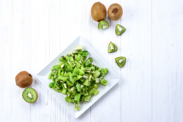 Freshly sliced kiwi fruit with whole kiwis in background.
