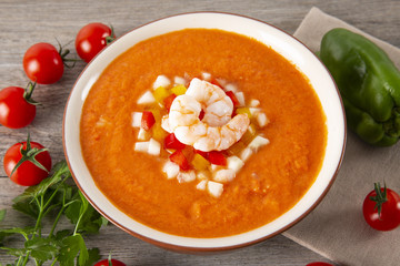 Soup gazpachos with shrimps, Italian cuisine. Plate with soup in a white plate on a rustic background. Top  Vieux.