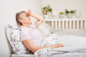 Alte Frau liegt krank im Bett