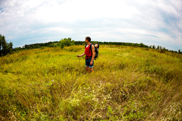 A man carries a child in a backpack.