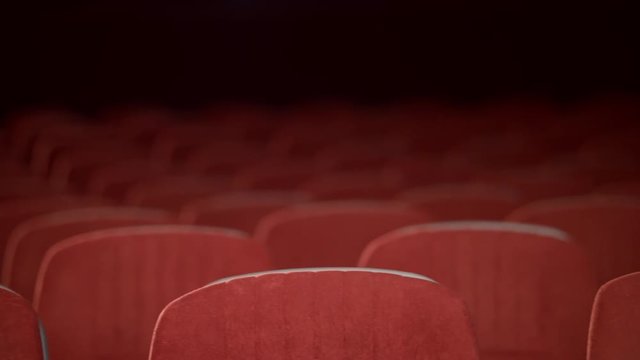 Empty cinema chair before premiere. Rows of empty seats in movie theatre. Comfortable armchairs in cinema hall. Theatre hall with red seats. Movie hall background