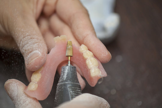 Close up Dental technician work on denture prothesis in dental laboratory