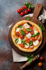 Italian pizza with tomatoes, mozzarella and basil