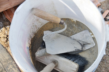 dirty bucket and tools trowel and paint brush