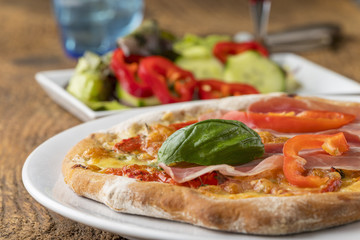 Detail einer Pizza mit Schinken und Basilikum