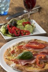 Detail einer Pizza mit Schinken und Basilikum