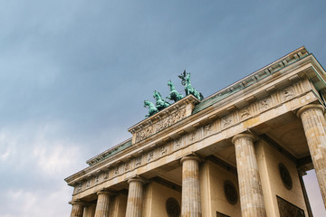Brandenburg gate in Berlin gainst the backdrop of the setting sun in the evening. Architectural monument in historic center of Berlin. Symbol and monument of architecture © franz12