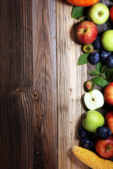 Various fresh fruits. Thanksgiving pumpkin, apples, and maize on rustic background.