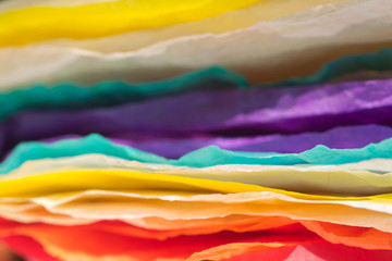 stack of multicolored creased paper tissue macro