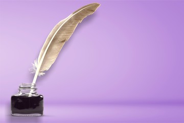 Feather quill pen and glass inkwell isolated