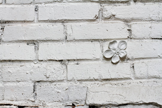 White brick wall with gypsum flower as background or texture © yulyao