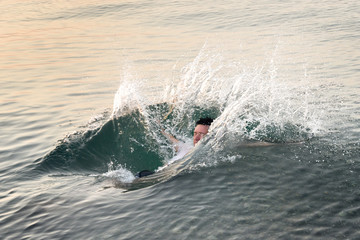 Fototapeta premium Young man falling in the water back with a bunch of squirts