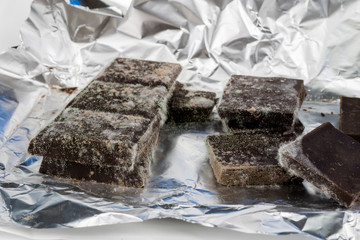 Moldy chocolate in the original packaging. Out-dated food products used for desserts.