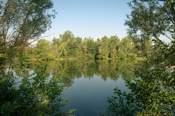 Lac de Lamartine, reflet des arbres sur l'eau. Vue sur le lac durant une journée d'été.Roques,...