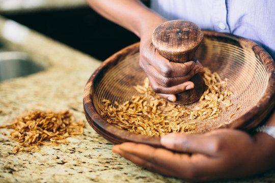 African-American Woman's Hands Crushing Seeds with Mortar and Pestle