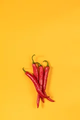 Keuken spatwand met foto Red hot chili pepper on yellow surface. Beautiful minimalist food art background © Victoria Kondysenko