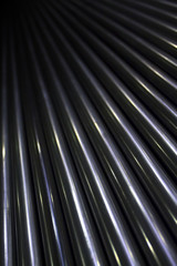 Pattern of lots of shiny stainless industrial metal steel pipe tubes to cut weld process and work with