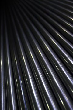 Pattern of lots of shiny stainless industrial metal steel pipe tubes to cut weld process and work with