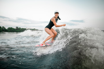 Active woman riding on the wakesurf on the bending knees