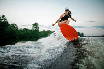 Young attractive girl jumping on the orange wakesurf