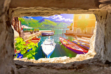 Limone sul Garda turquoise waterfront and boats view through stone window