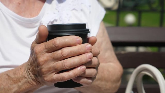 Close-Up Hands Of Senior Woman Holding Takeaway Coffee.