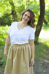 Fototapeta premium The happy Russian woman walks in the wood in the summer.