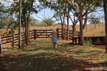 menina caminhando nas árvores sítio chácara família