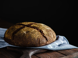 Rye homemade bread on a wooden background.