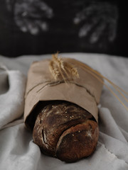 Homemade rye bread wrapped in kraft paper.
