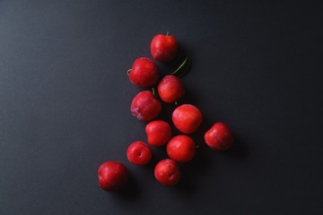 Red sweet cherry plums on dark background. Overhead view