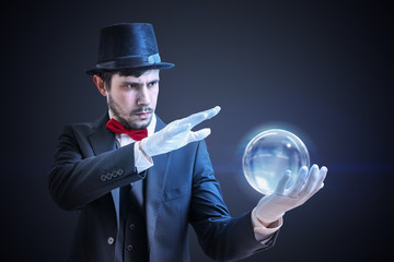 Young illusionist is predicting future and fortune telling from magical ball.