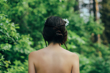 back of beautiful woman walking in sunny forest, enjoying travel in summer