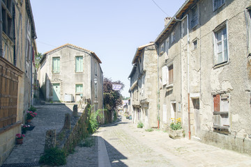 Fototapeta na wymiar Streets and buildings of medieval french old town in summer on a sunny day