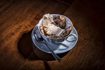 A cup with a spoon and tea bags