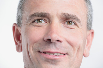 Portrait of successful mature business man smiling against white