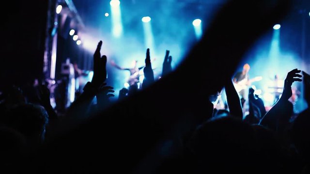 concert crowd of people applauding to musicians at music festival, silhouettes of clapping hands, applause