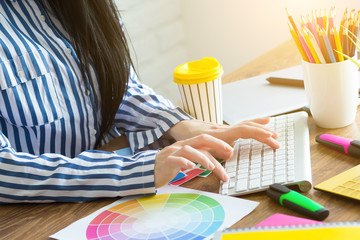 Young female designer using graphics tablet while working with computer