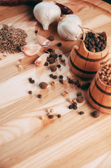 Spices: chili, black pepper, garlic, cumin, coriander, sweet pepper lie on a brown round wooden board on a black table. Place under the text.