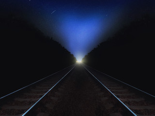 Night railway road closeup goes into the distance on the starry sky background and lights. Night landscape with stars and road