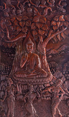 Buddha image carved from a wooden on wall temple in Thailand.
