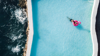 A loving couple in the pool on an inflatable pink flamingo with an ocean view © Irina