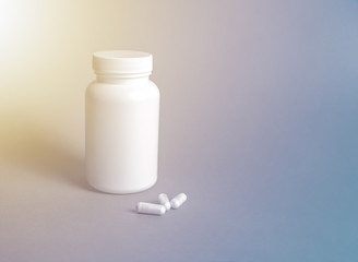 White bottle with capsules inside, white capsules, medicines, copy space