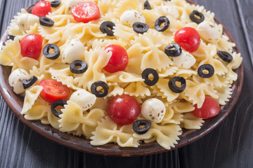 Pasta salad with mozzarella , olives and tomatoes