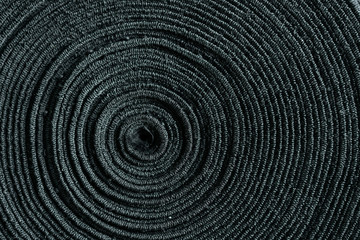 Fototapeta na wymiar Black cloth roll from the center. Texture of Macro Cloth.