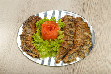 Sliced herring on a plate with herbs.